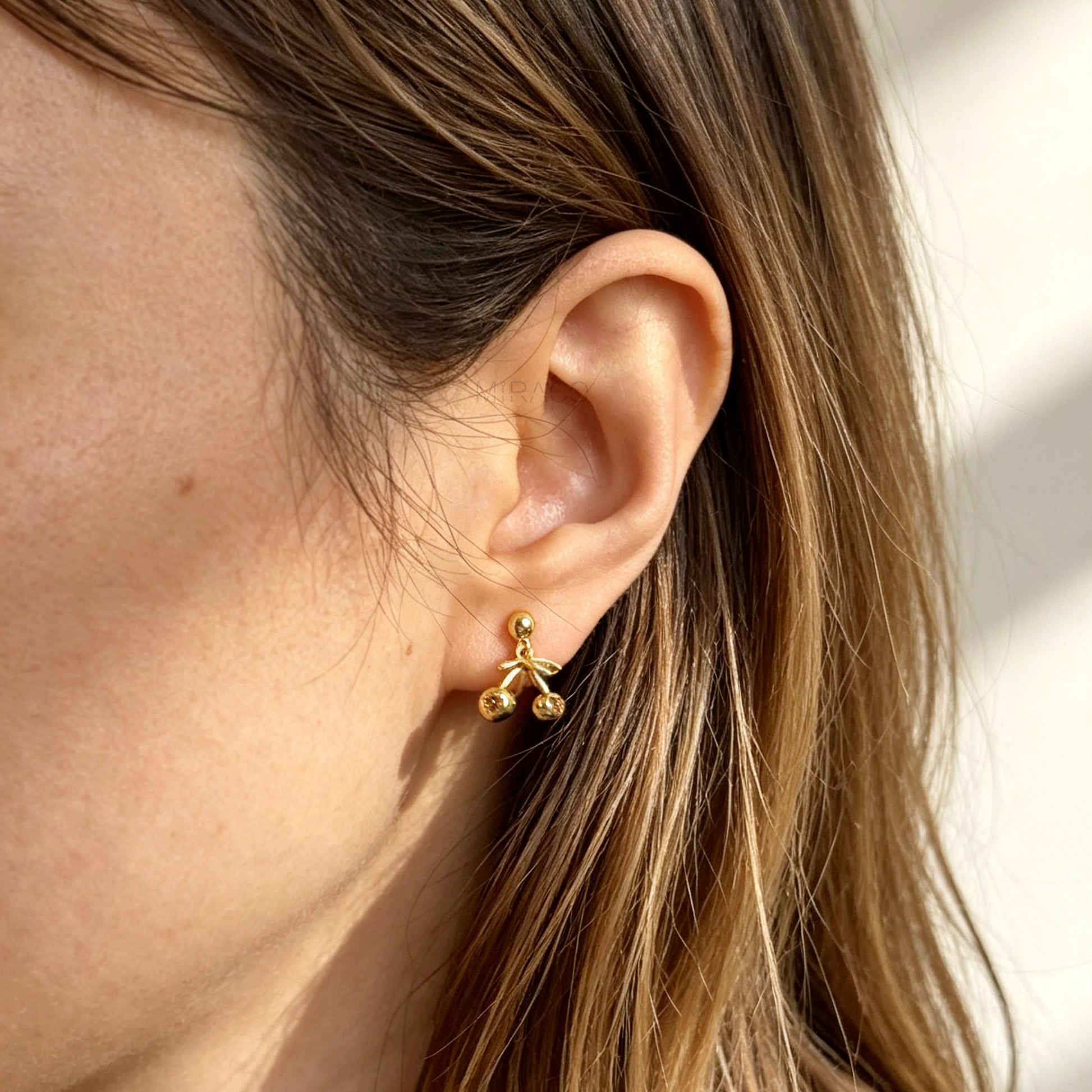 gold-toned double cherry clip-on earrings with amber rhinestone accents and comfortable silicone-backed spiral coil clips.