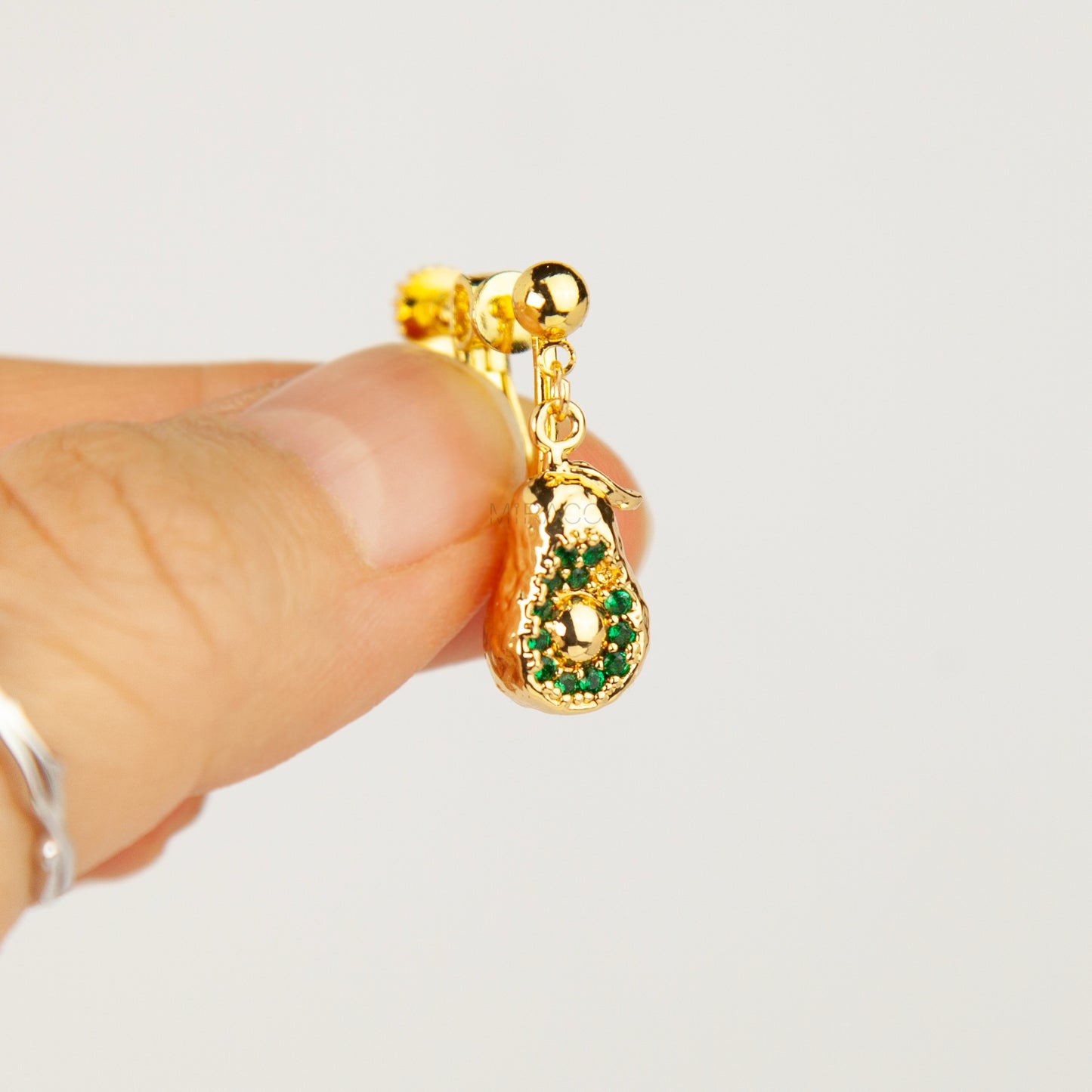 Pair of gold-toned non-pierced avocado clip-on drop earrings with green crystal accents and adjustable screw-back mechanisms.