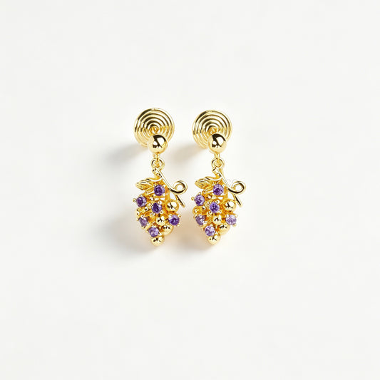 Pair of gold grape cluster clip-on drop earrings encrusted with purple crystals featuring pain-free coil backs for non-pierced ears on a white background.