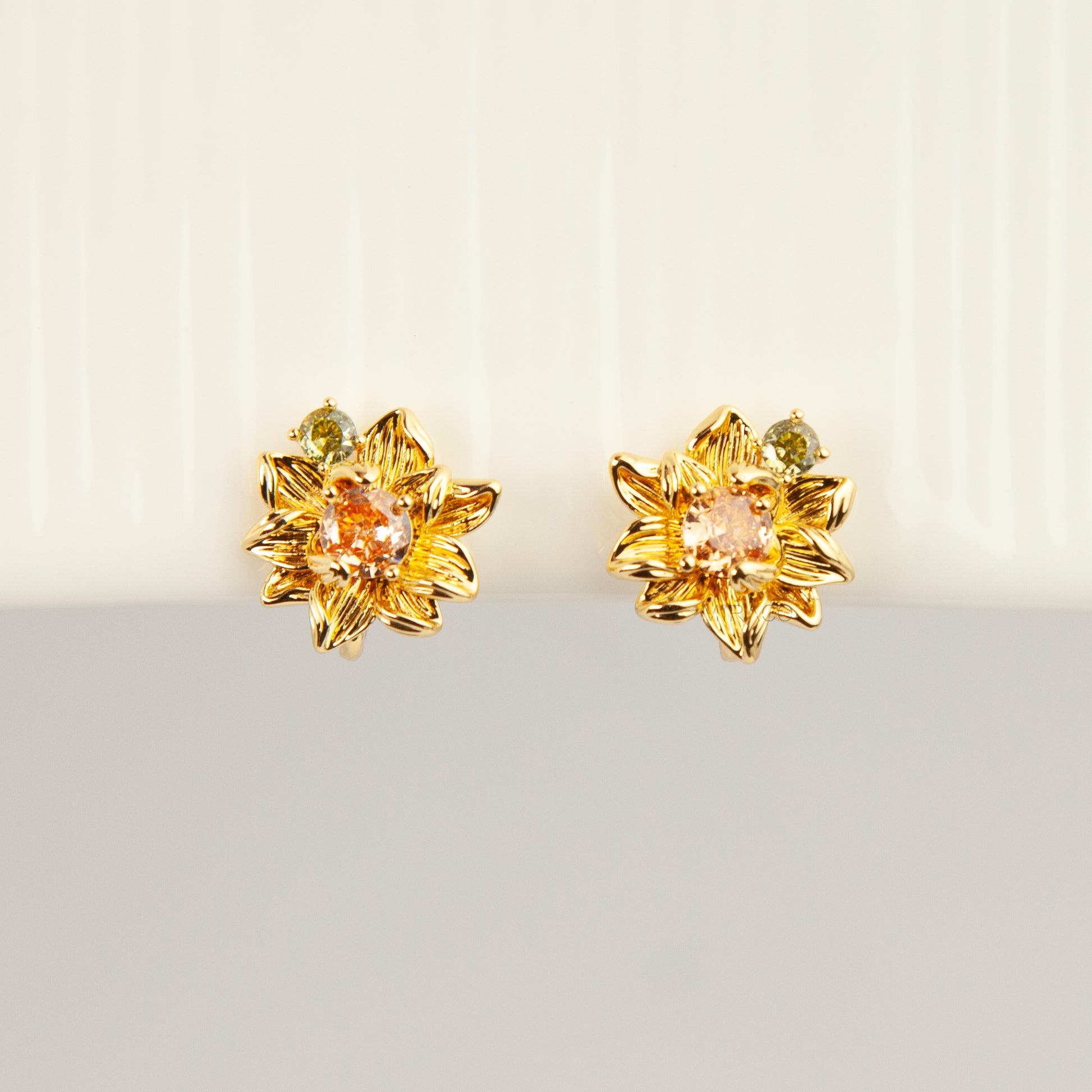 Pair of detailed gold sunflower clip-on stud earrings with amber crystal centers and olive green stone accents