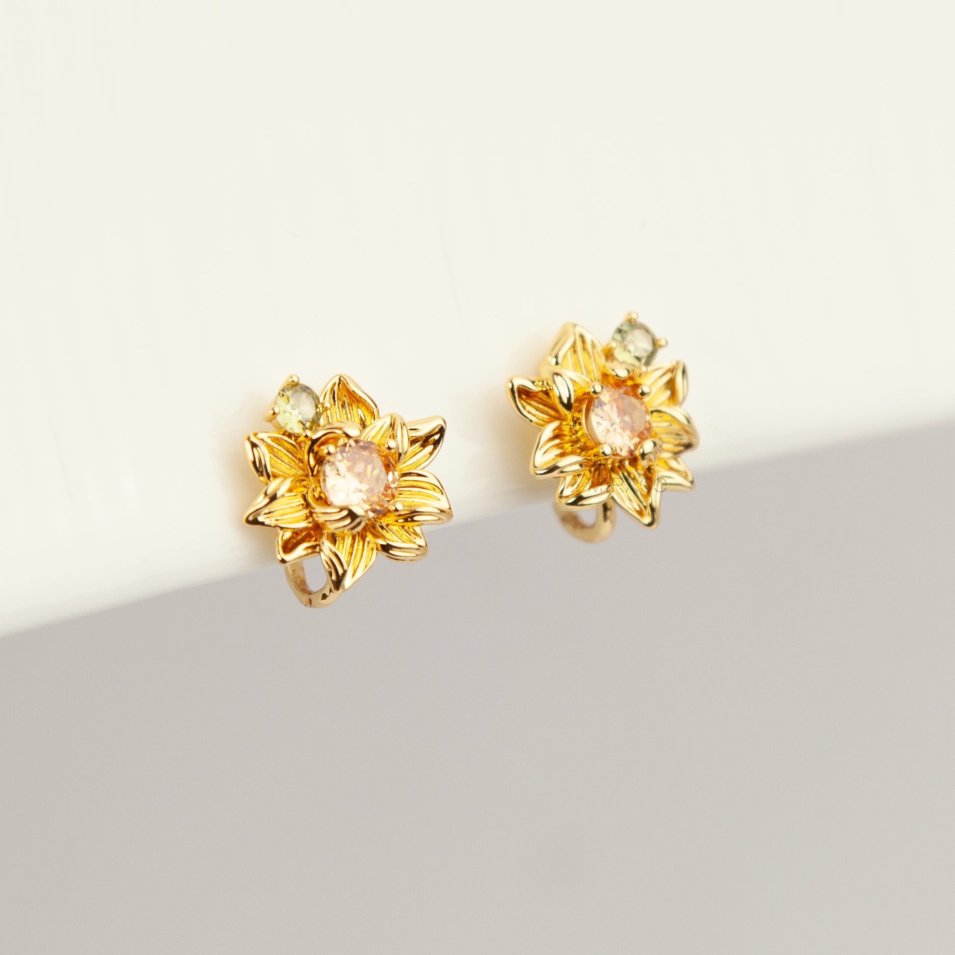 Pair of detailed gold sunflower clip-on stud earrings with amber crystal centers and olive green stone accents