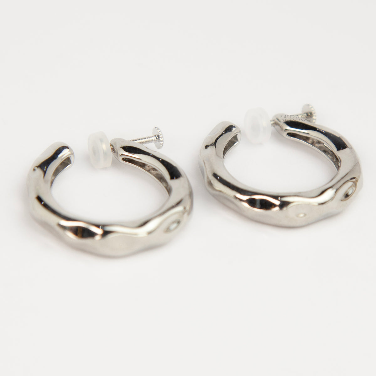 Silver chunky molten clip-on hoop earrings with adjustable screw-back closures featuring an organic wavy textured finish