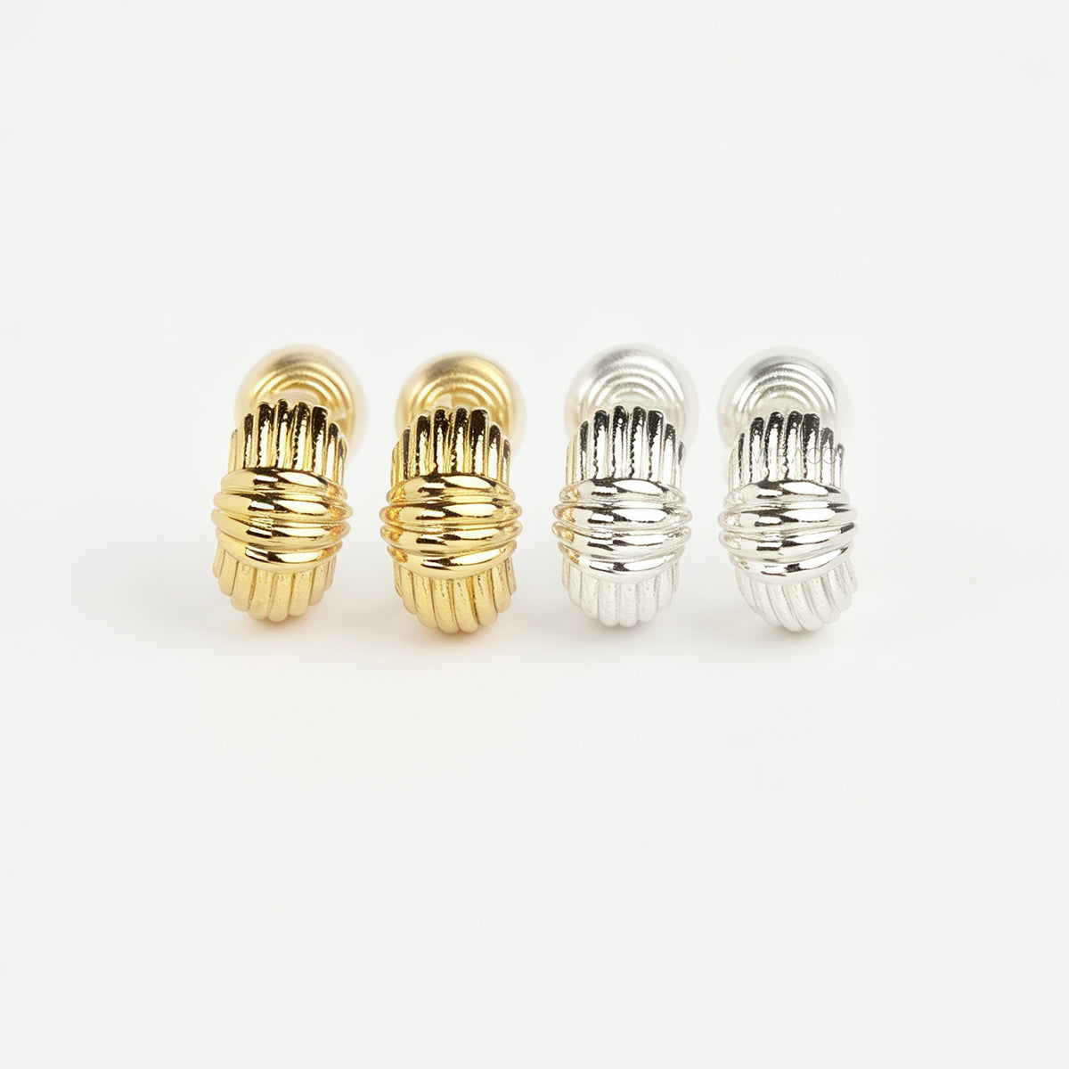 Gold and silver textured ribbed coil-back clip-on stud earrings displayed side by side