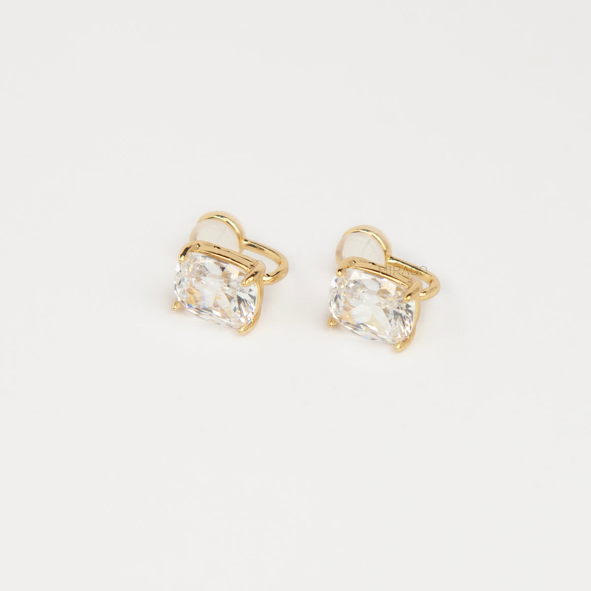 Gold-tone clip-on stud earrings set with large cushion-cut clear crystals and round silicone backs 