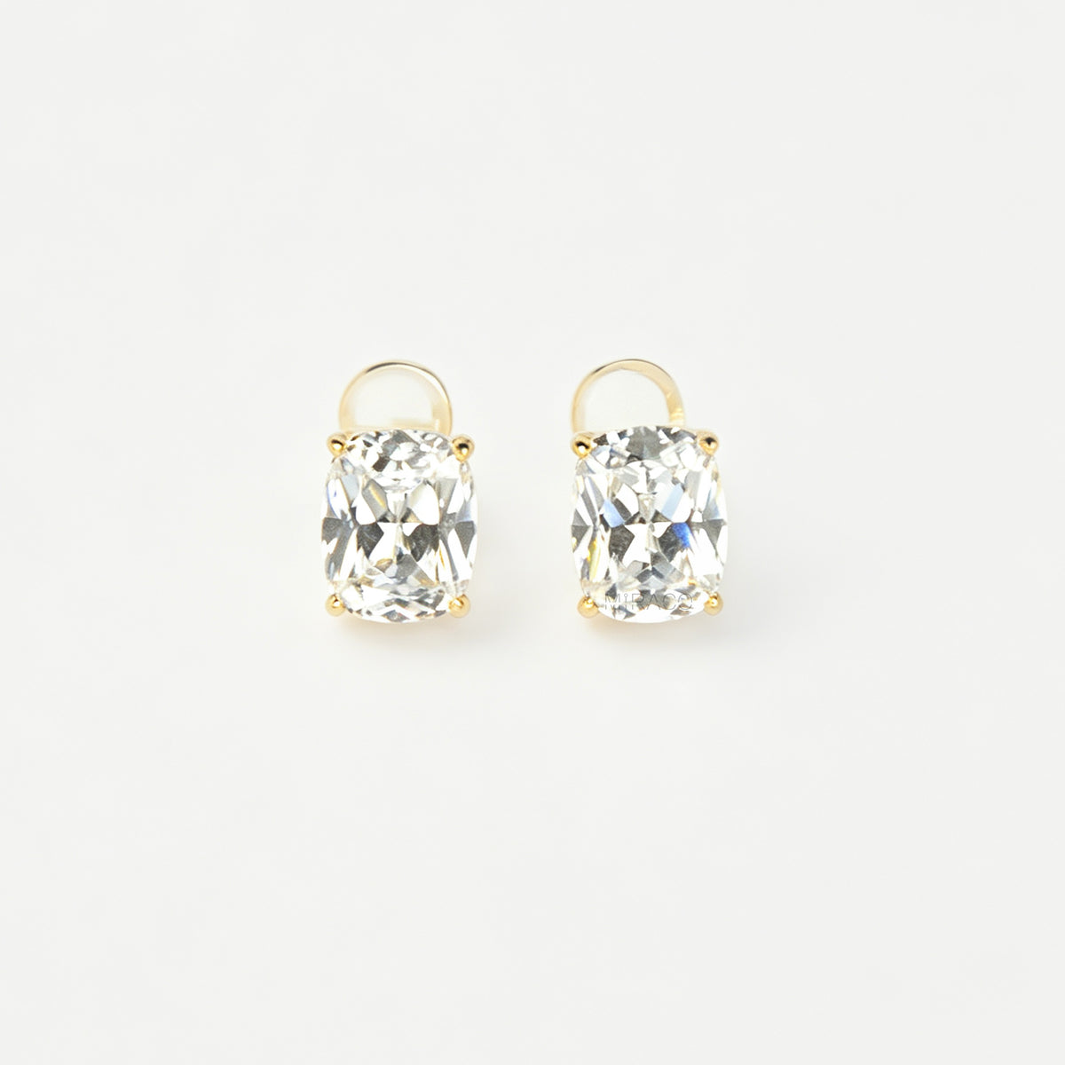 Gold-tone clip-on stud earrings set with large cushion-cut clear crystals and round silicone backs 