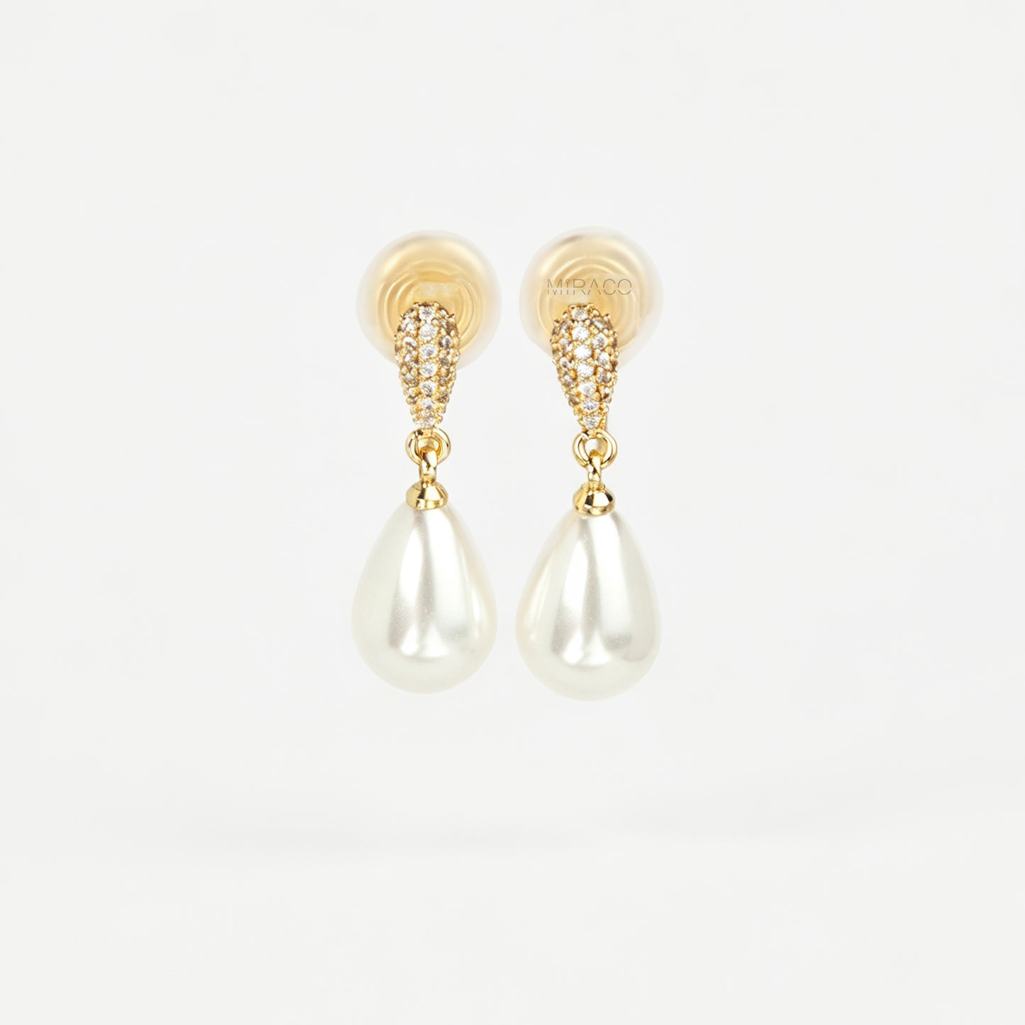 Gold coil-back clip-on drop earrings featuring a pave crystal teardrop stud and dangling white pear-shaped pearl 