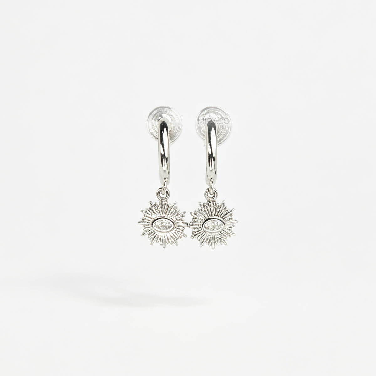 Silver coil-back clip-on hoop earrings featuring a dangling sunburst charm with a central oval crystal evil eye motif 