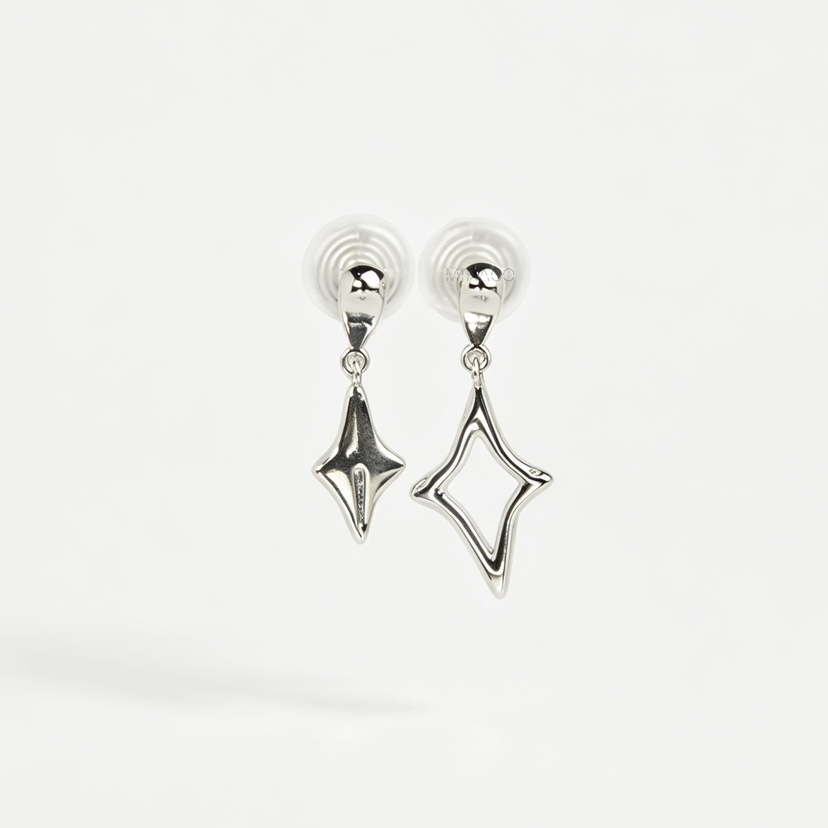 Silver coil-back clip-on drop earrings featuring mismatched solid and hollow four-point starburst charms