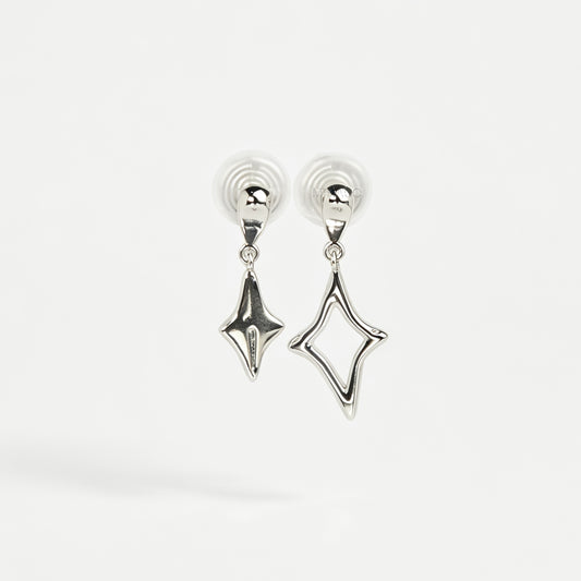 Silver coil-back clip-on drop earrings featuring mismatched solid and hollow four-point starburst charms