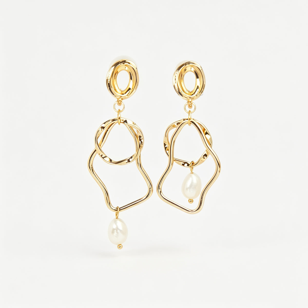 Gold coil-back clip-on statement earrings featuring abstract wavy geometric hoops and dangling teardrop pearl accents.