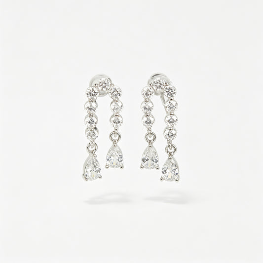 Silver non-pierced clip-on arch earrings with round silicone backs, paved with round cubic zirconia and finished with dangling teardrop crystal gems