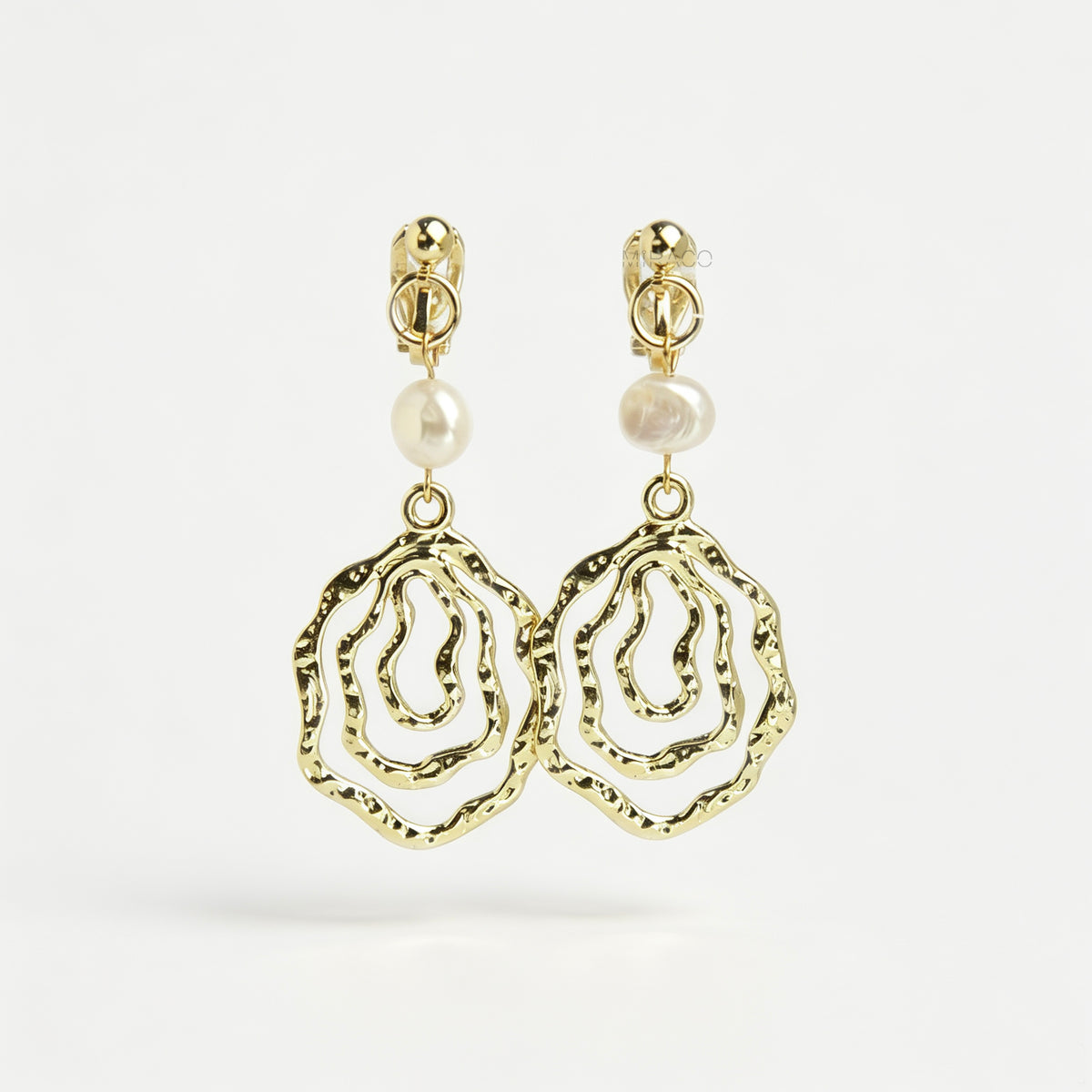 Gold mini-clip clip-on drop earrings featuring a natural freshwater pearl above a concentric hammered wavy openwork pendant