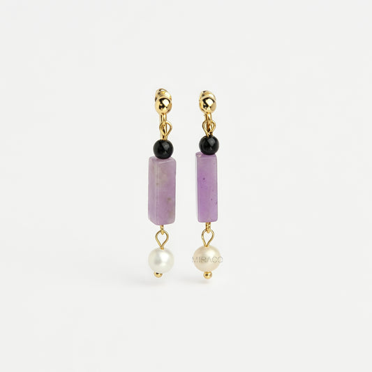 Gold screw-back clip-on drop earrings featuring a black onyx bead, rectangular purple jade stone, and dangling white freshwater pearl.