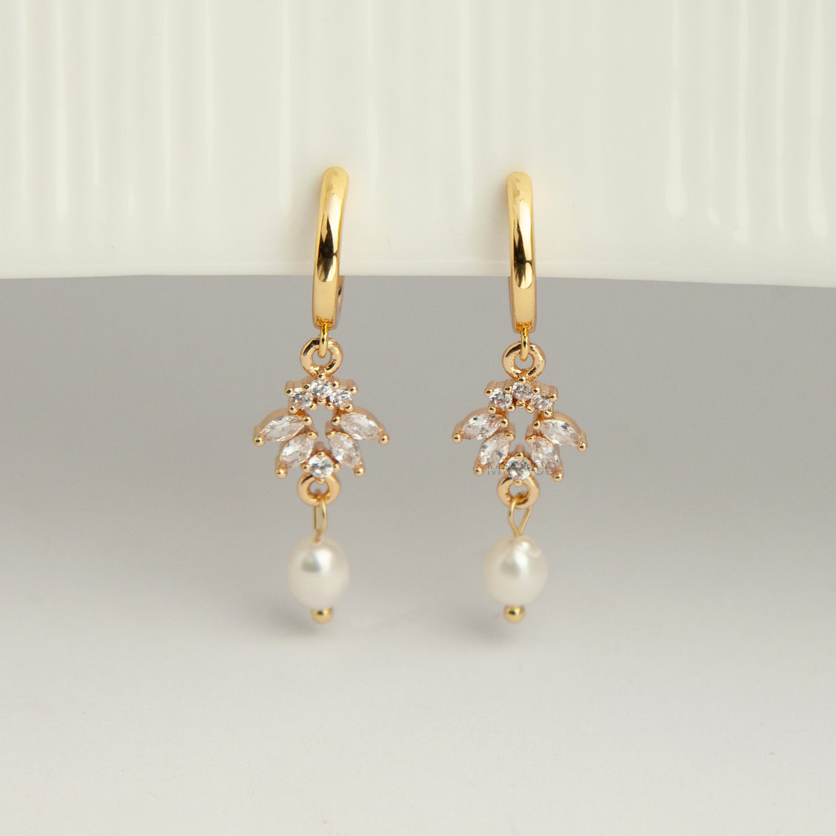 Gold screw-back clip-on hoop earrings with a sparkling cubic zirconia marquise sunburst charm and hanging white pearl drop