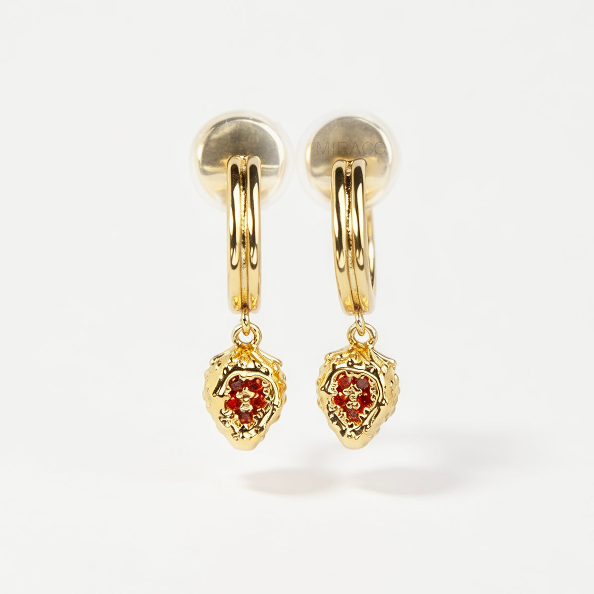 Gold clip-on hoop earrings featuring textured strawberry pendants set with sparkling red crystals and clear cushion backings.