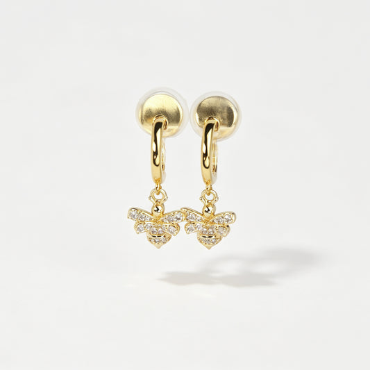 Gold clip-on hoop earrings with a sparkling cubic zirconia pave bumblebee charm and comfortable round cushion backings.