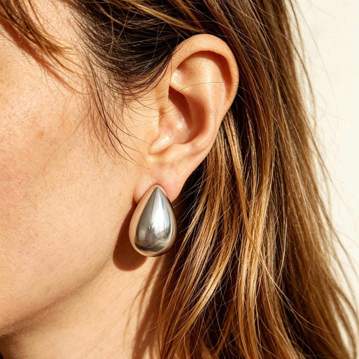 Polished gold and silver teardrop waterdrop clip-on earrings with mini-clip backings displayed side-by-side on a plain white background.