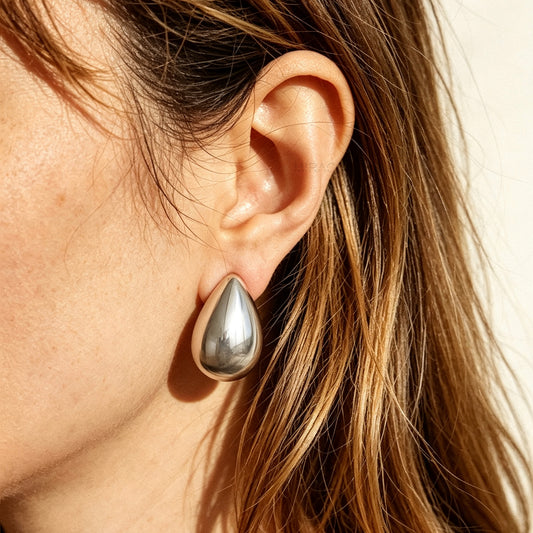 Polished gold and silver teardrop waterdrop clip-on earrings with mini-clip backings displayed side-by-side on a plain white background.