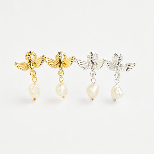 Gold and silver bird clip-on drop earrings featuring detailed flying bird motifs with dangling genuine freshwater baroque pearls on cushioned coil backs.