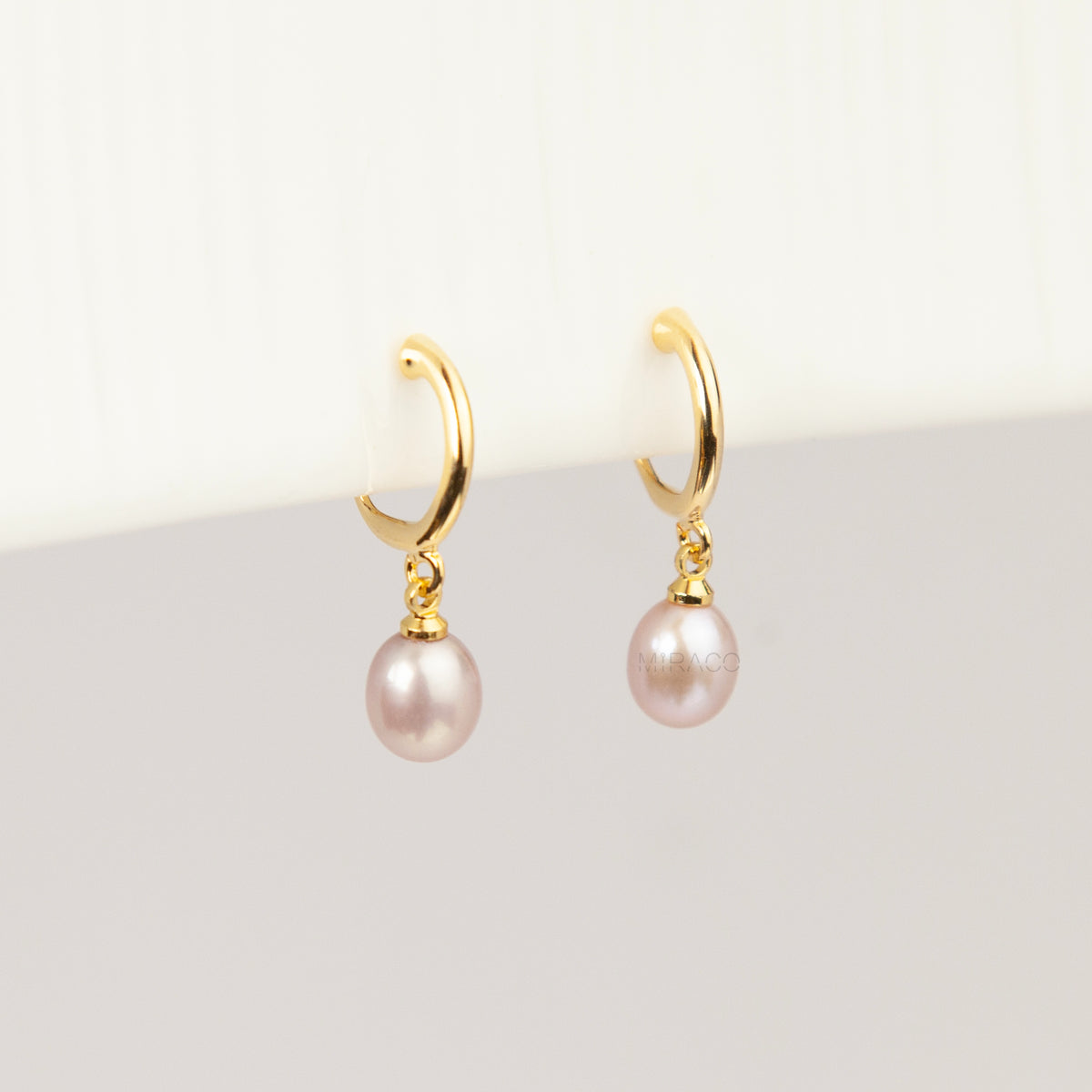 gold clip-on hoop earrings with a teardrop purple freshwater pearl dangle and coil back for non-pierced ears.