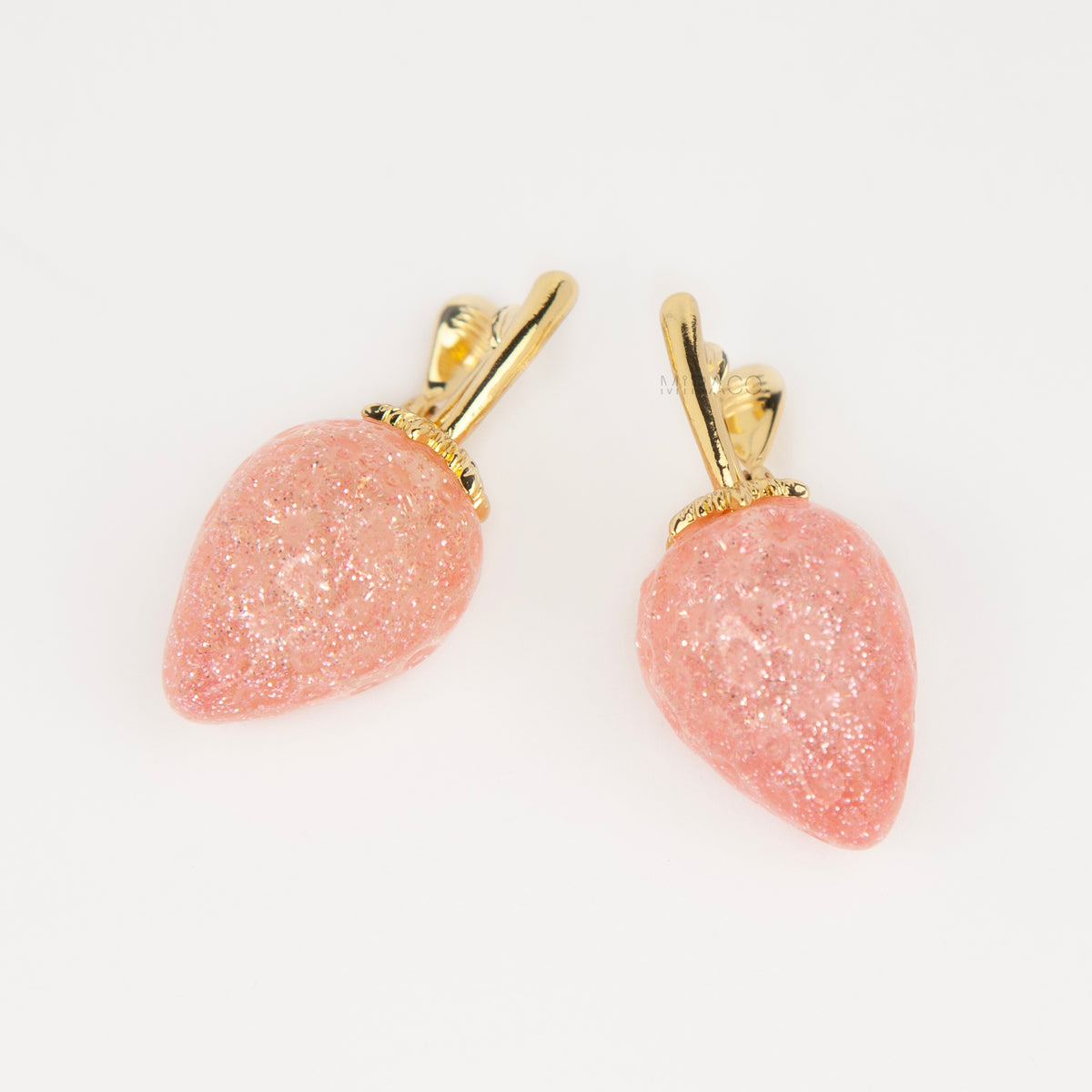 sparkling pink resin strawberry clip-on drop earring with a gold foldable paddle back for non-pierced ears.