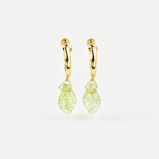 gold clip-on hoop earrings with light green carved glass leaf drops featuring an adjustable screw back for non-pierced ears.