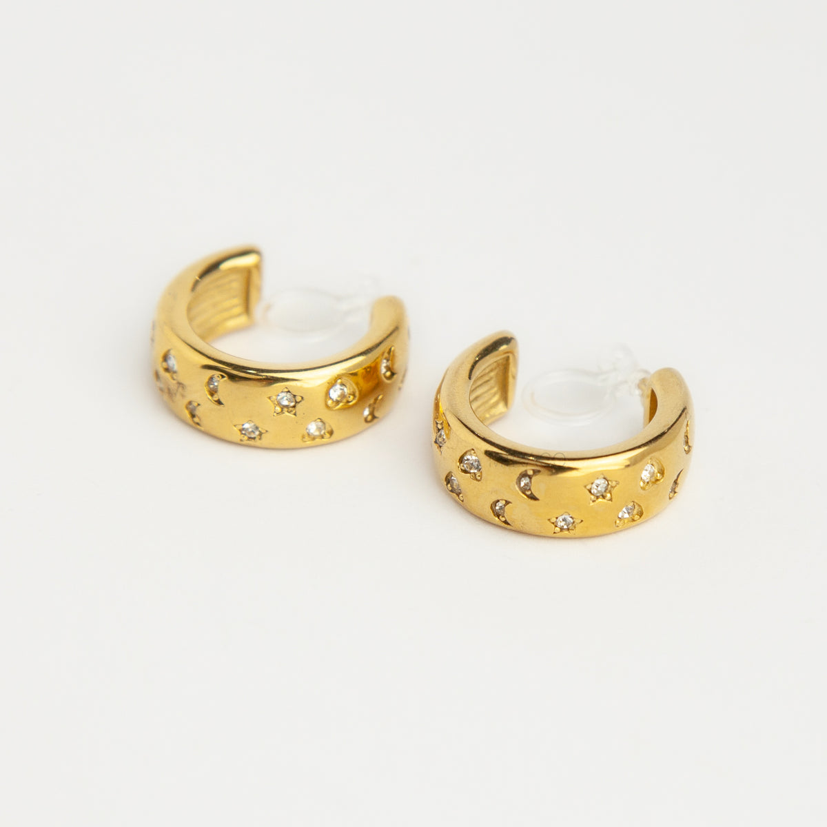 gold celestial star and moon cubic zirconia chunky hoop clip-on earrings with invisible clear resin backs for non-pierced ears.