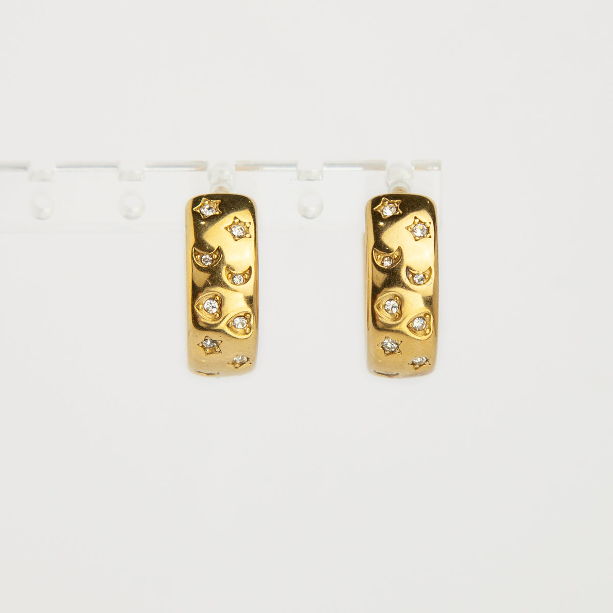 gold celestial star and moon cubic zirconia chunky hoop clip-on earrings with invisible clear resin backs for non-pierced ears.