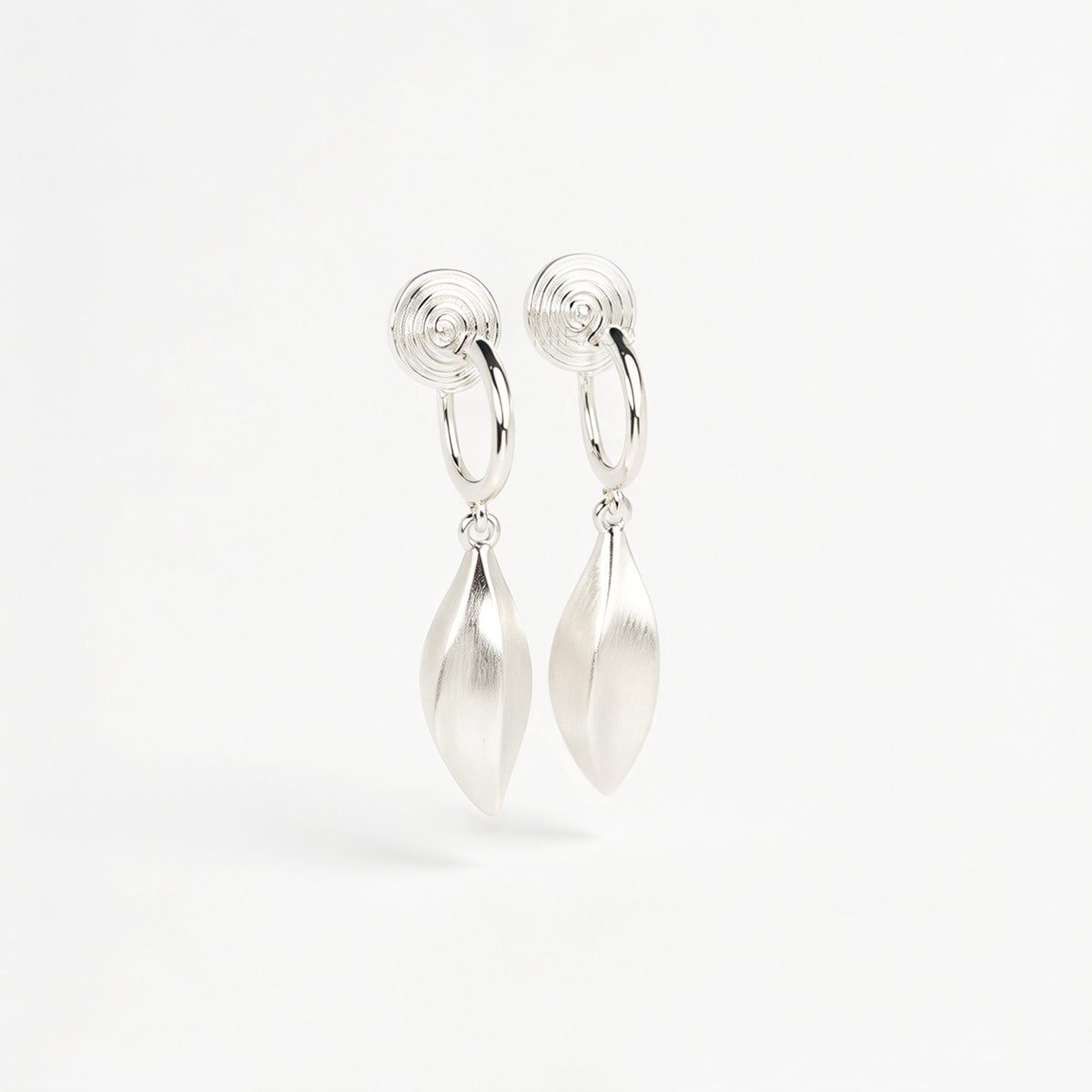 silver clip-on hoop earrings with brushed leaf drop pendants featuring a spring coil back for non-pierced ears.