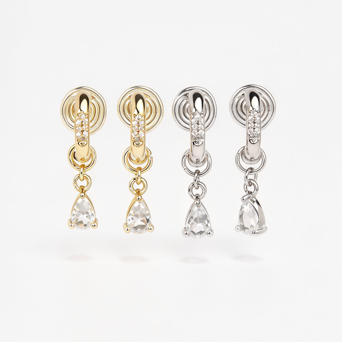 Gold and silver huggie clip-on hoop earrings with pavé cubic zirconia and teardrop CZ drop pendants featuring coil backs for non-pierced ears.