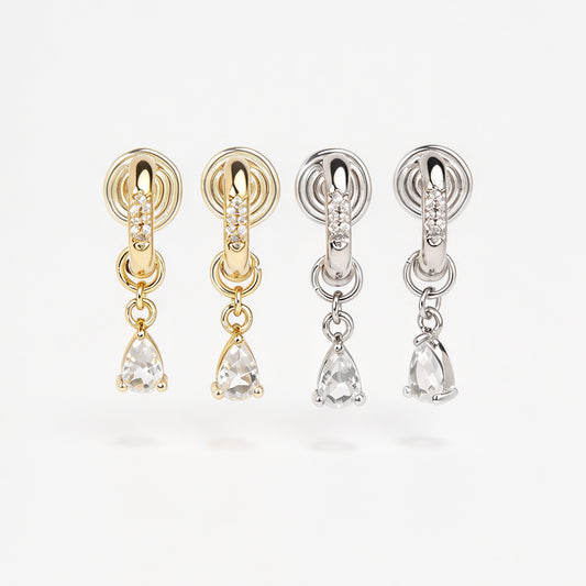 Gold and silver huggie clip-on hoop earrings with pavé cubic zirconia and teardrop CZ drop pendants featuring coil backs for non-pierced ears.