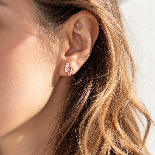 Rose gold clip-on earrings with cushioned round silicon backs, featuring a polished smooth bar and a paved cubic zirconia bar.