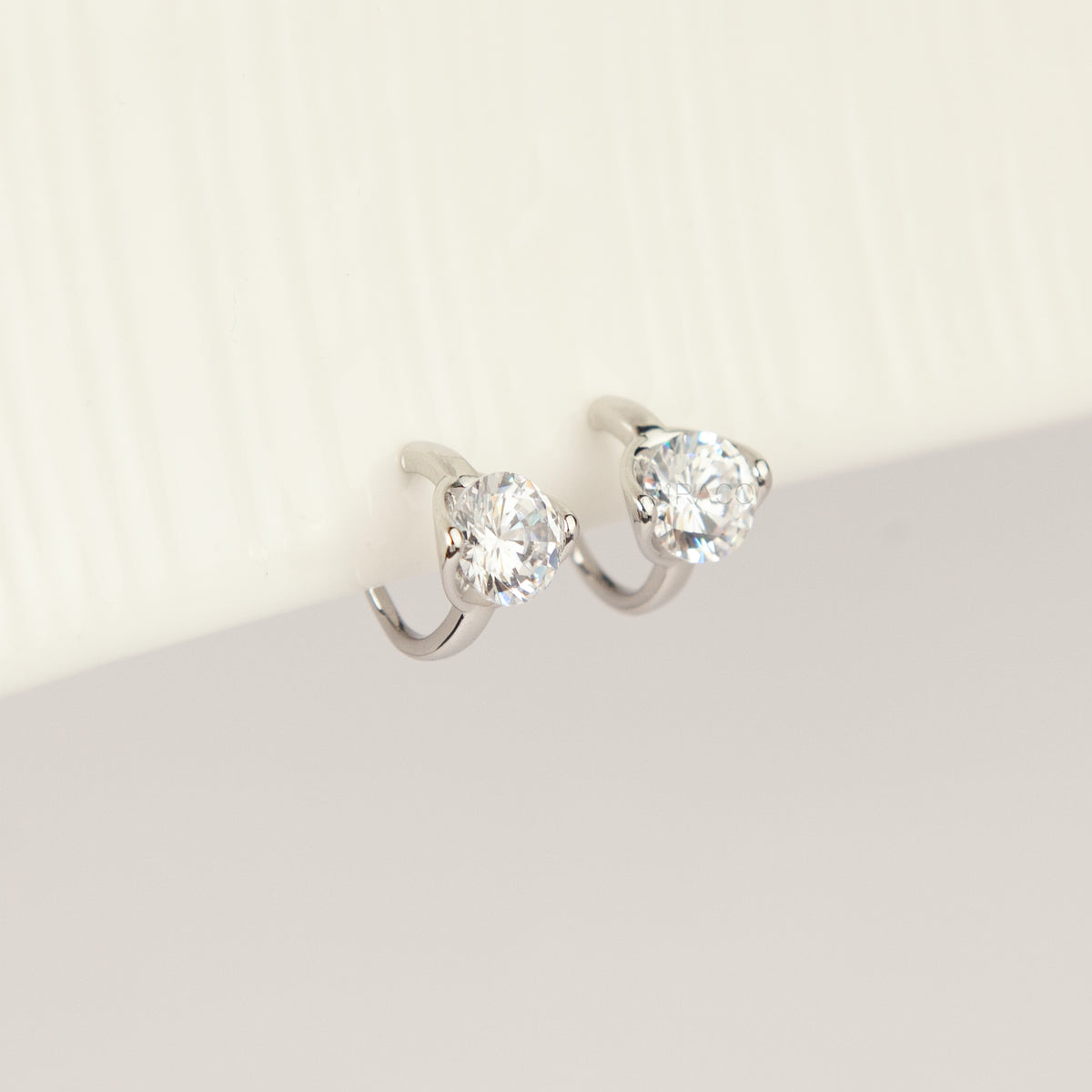 Silver solitaire cubic zirconia clip-on earrings with soft round silicon backings for non-pierced ears.