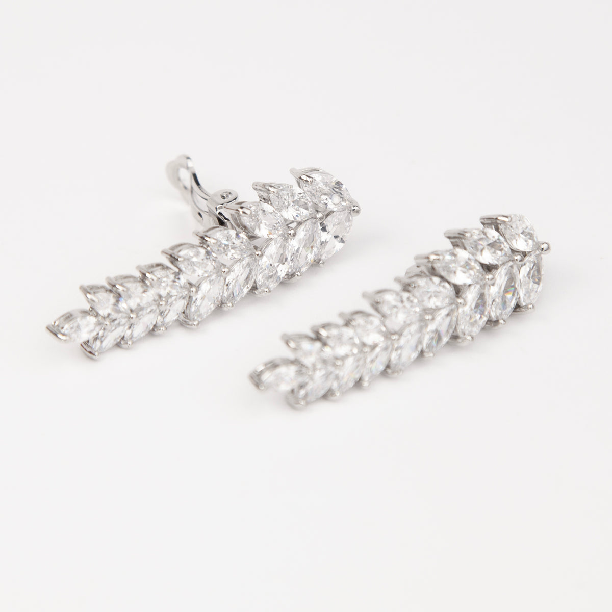Pair of silver marquise cubic zirconia leaf drop clip-on earrings with paddle backs.