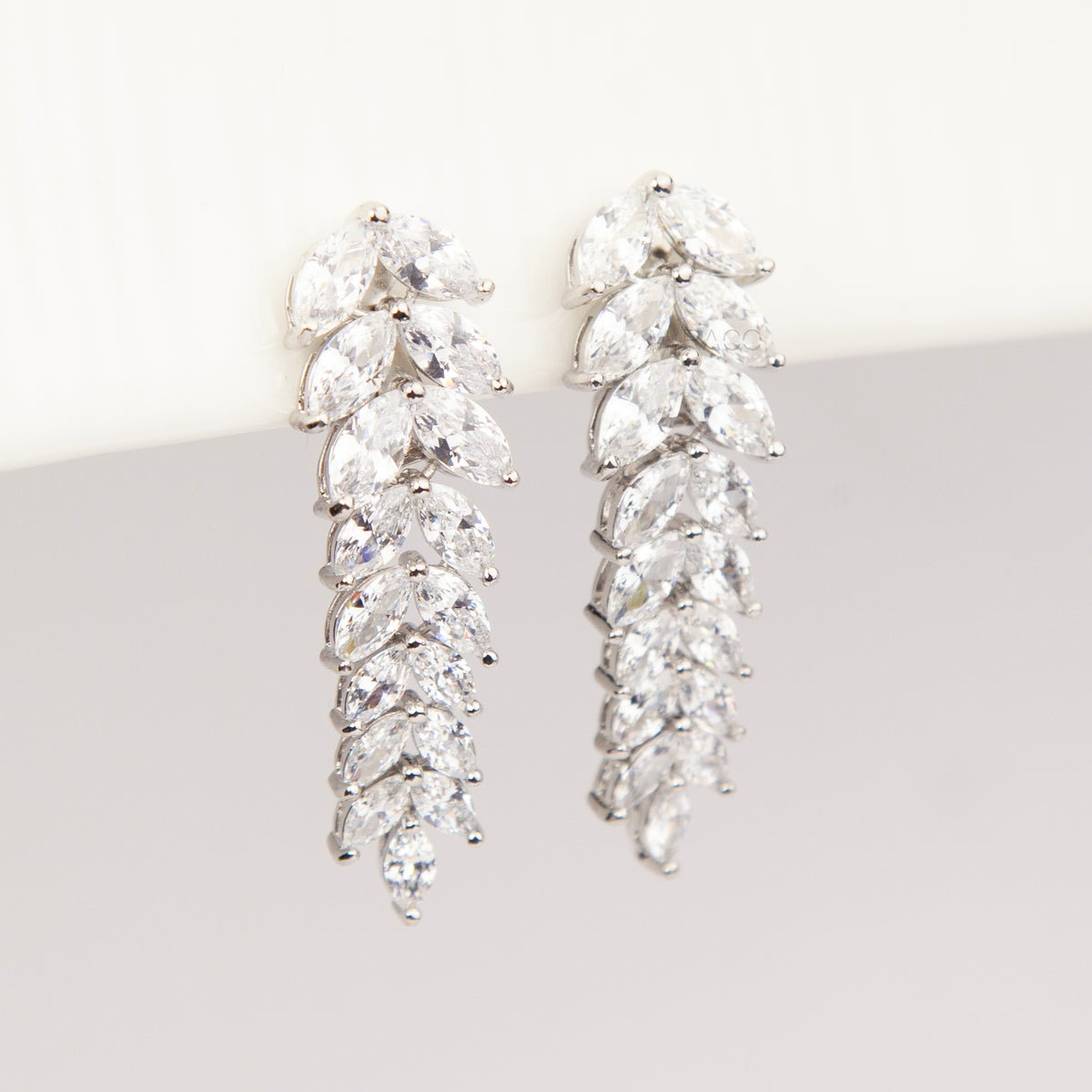 Pair of silver marquise cubic zirconia leaf drop clip-on earrings with paddle backs.