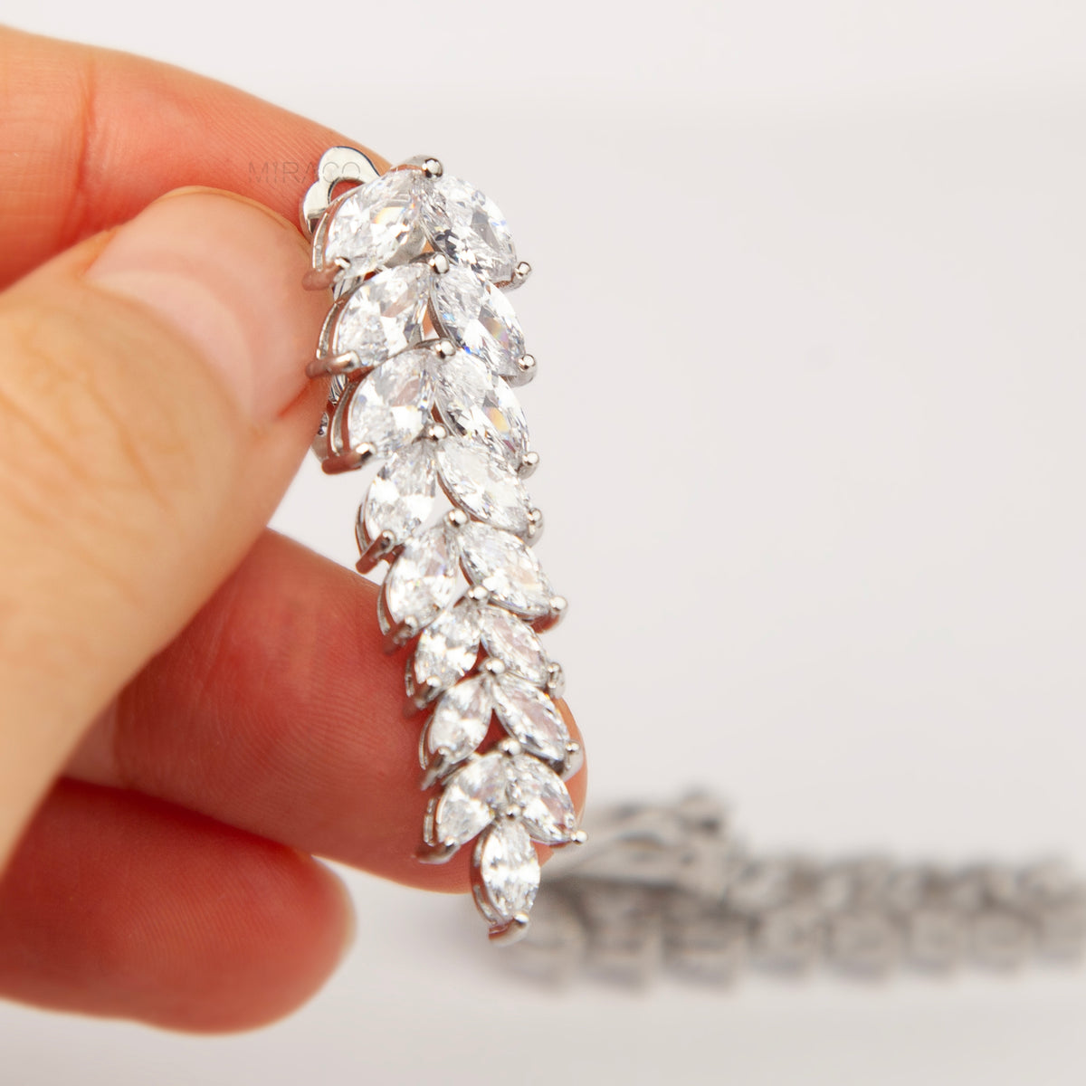 Pair of silver marquise cubic zirconia leaf drop clip-on earrings with paddle backs.