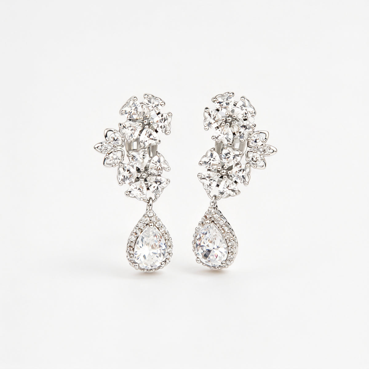 Silver floral cluster clip-on earrings featuring a halo pear-cut cubic zirconia teardrop with paddle backs.