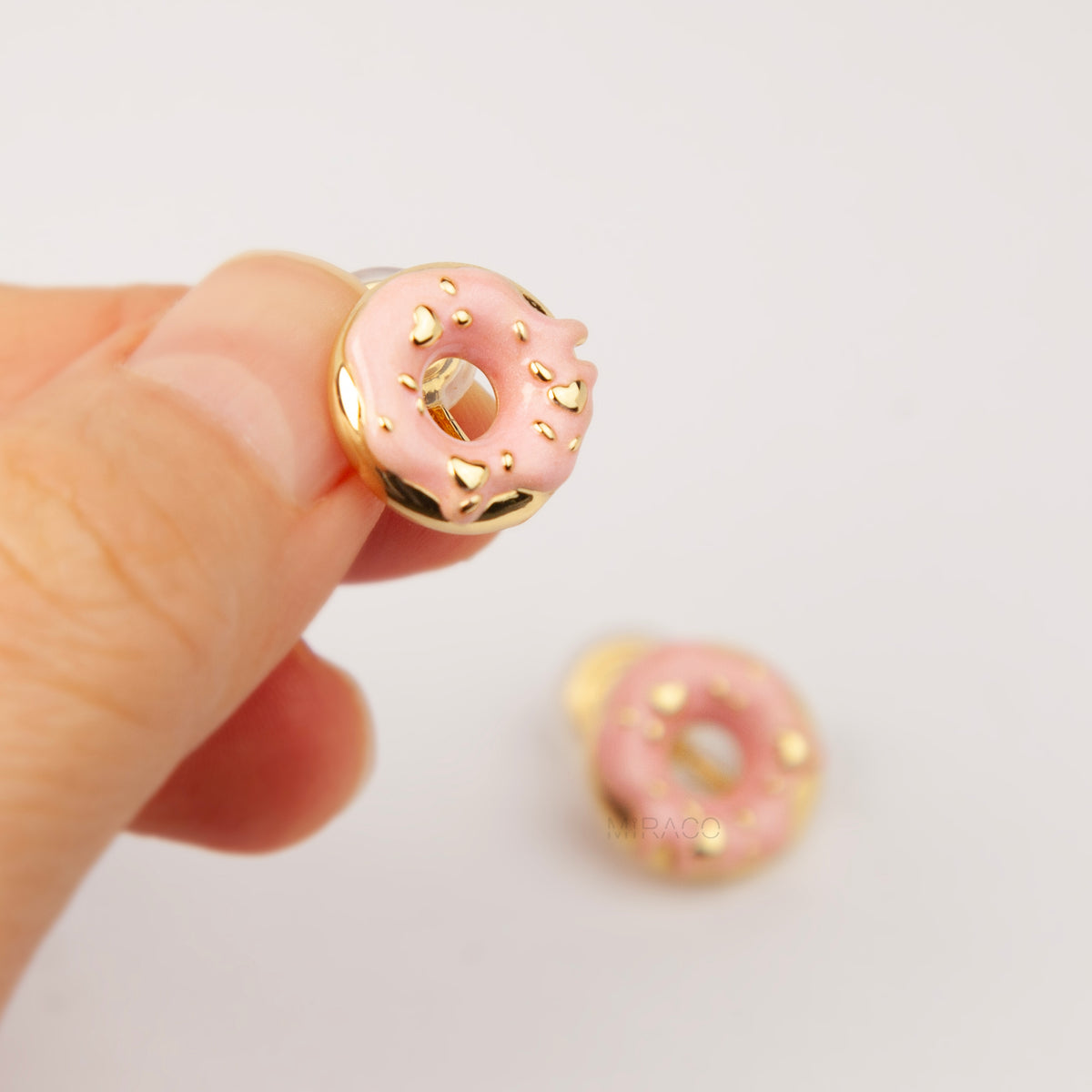 pink enamel donut clip-on earrings with gold sprinkles and coil back non-pierced closure