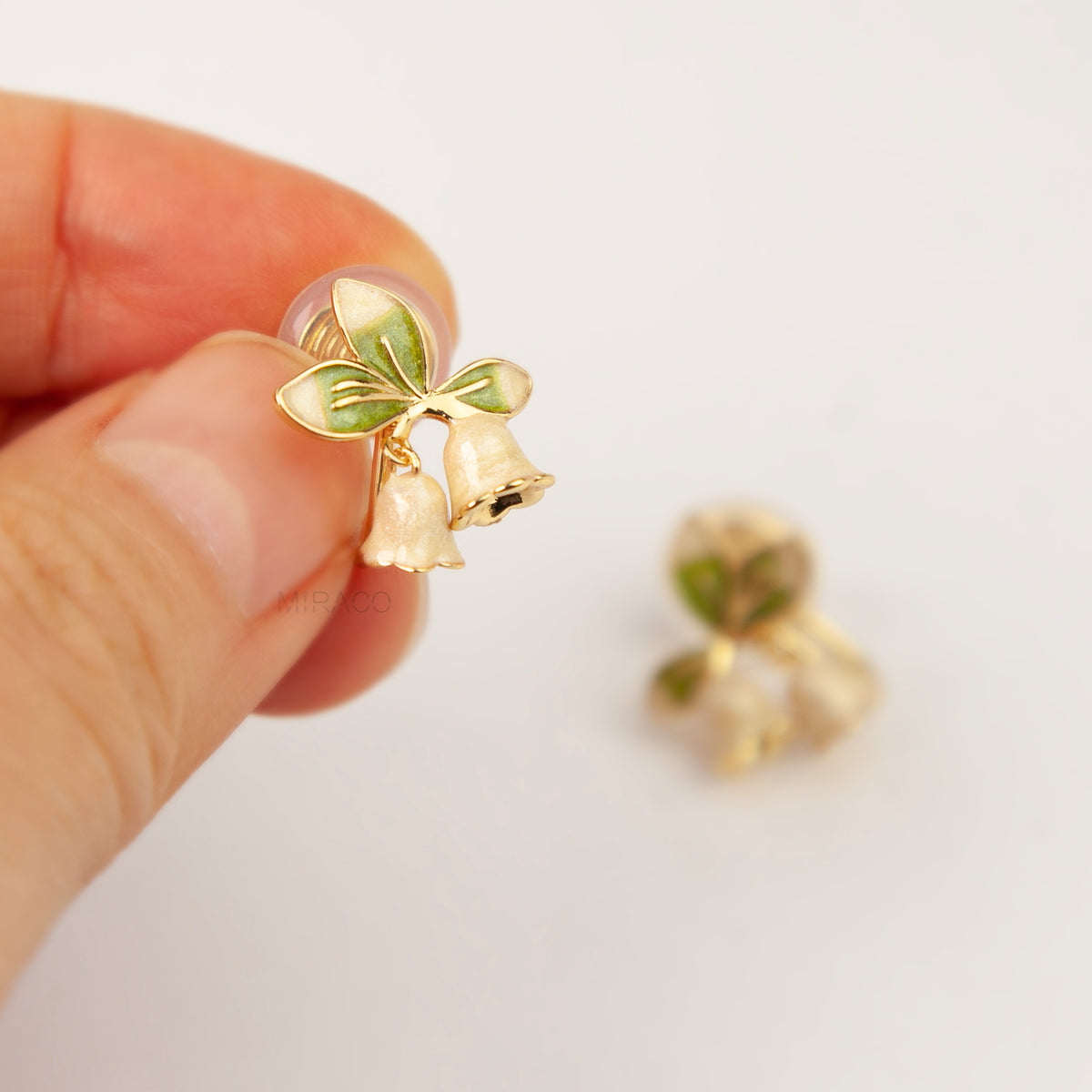 Lily of the Valley floral coil back clip-on earrings with green enamel leaves and pearlescent white flower drops