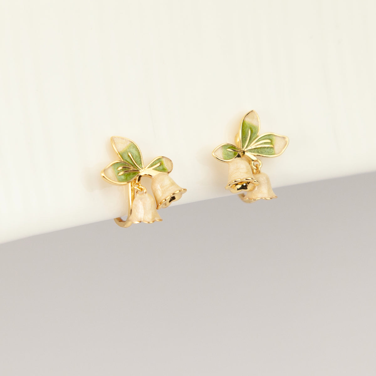 Lily of the Valley floral coil back clip-on earrings with green enamel leaves and pearlescent white flower drops