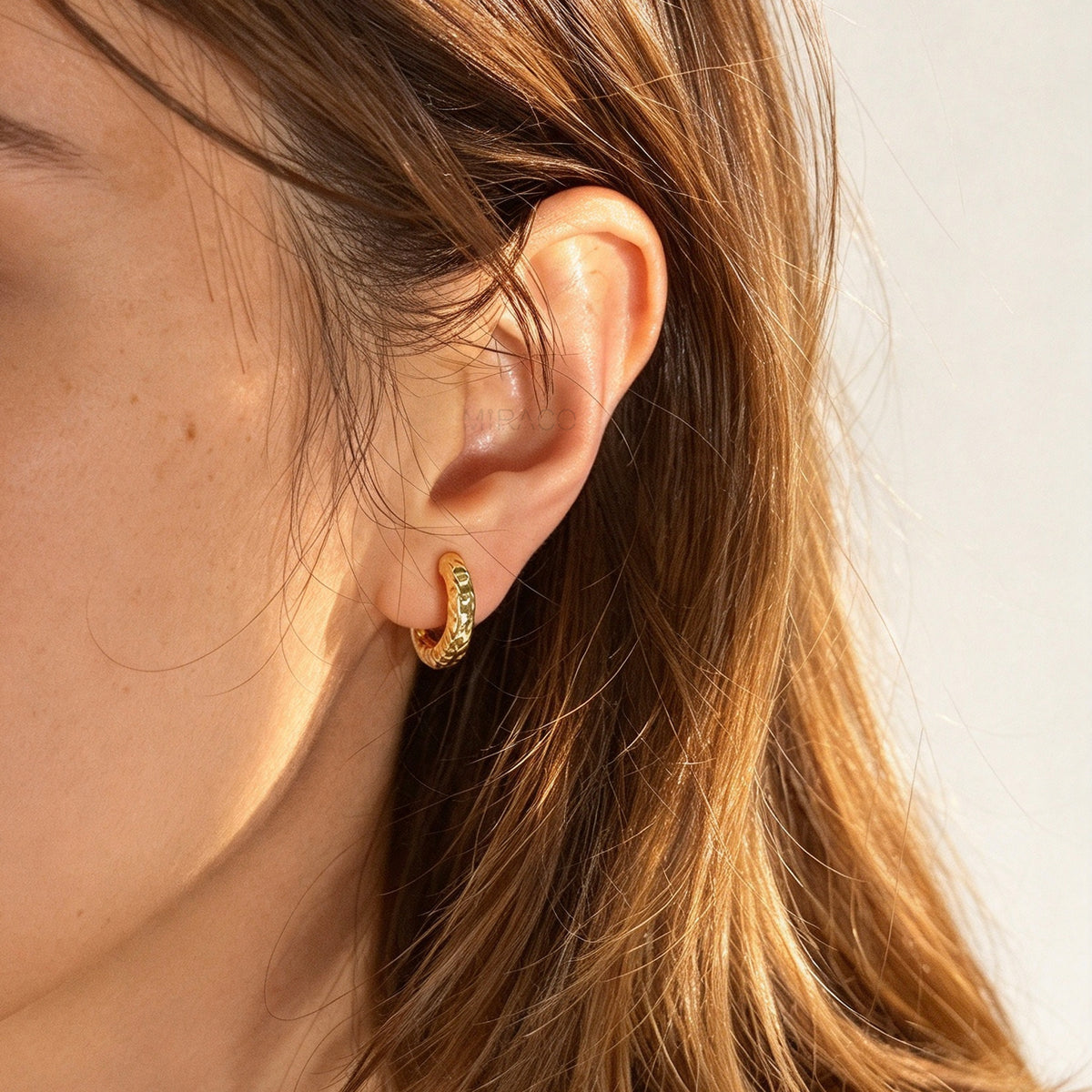 Gold textured molten chunky hoop clip-on earrings with adjustable screw back closures and silicone comfort pads.