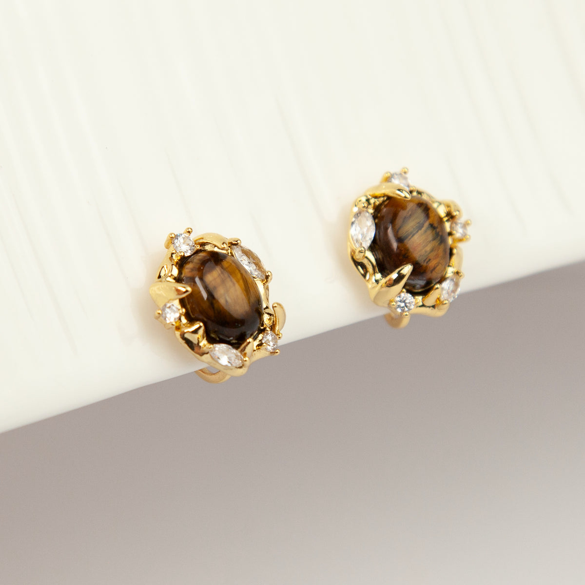 vintage oval tiger's eye cabochon clip-on earrings with cubic zirconia halo accents and coil back non-pierced closure