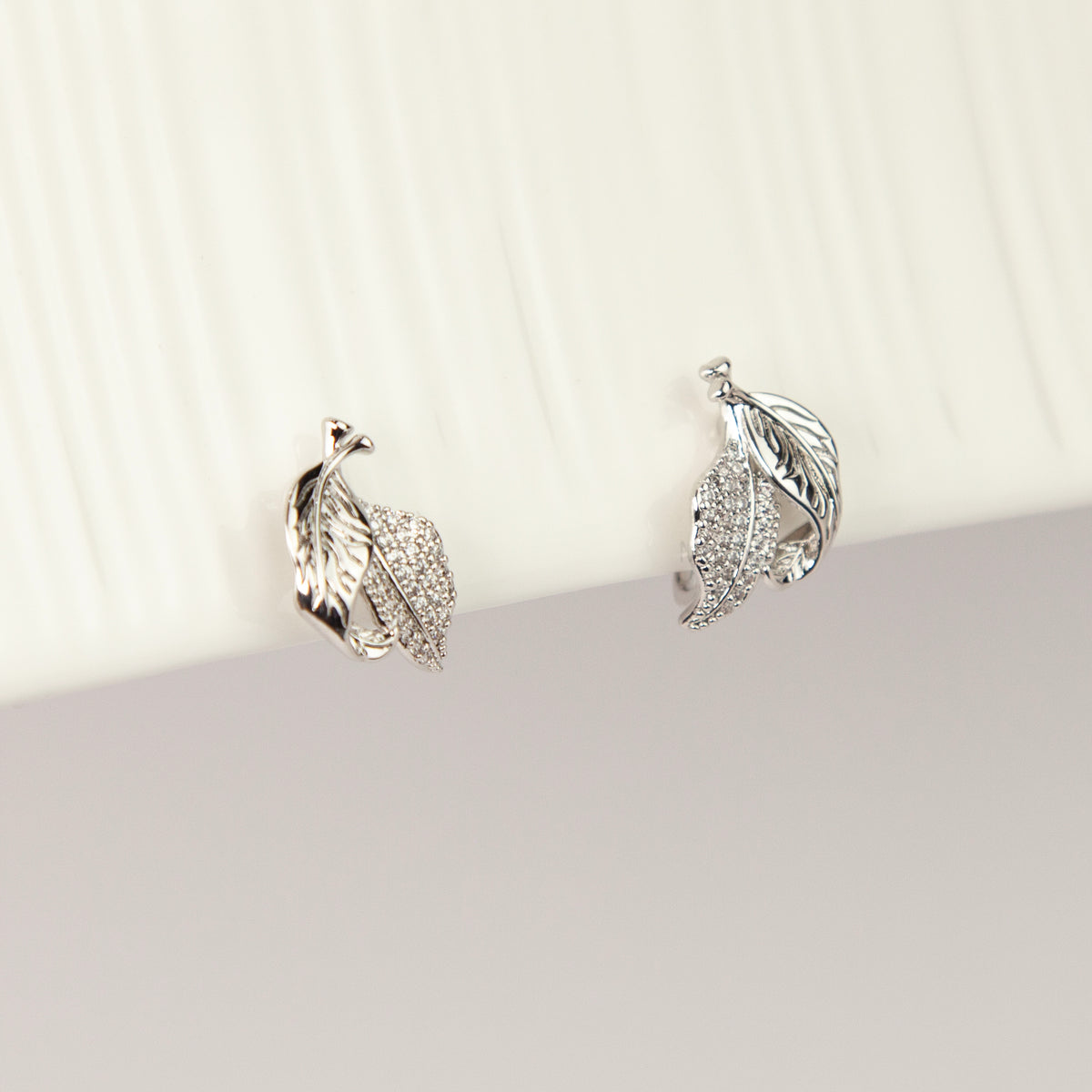 silver pavé crystal feather leaf pendant necklace and matching coil back clip-on earrings for unpierced ears.