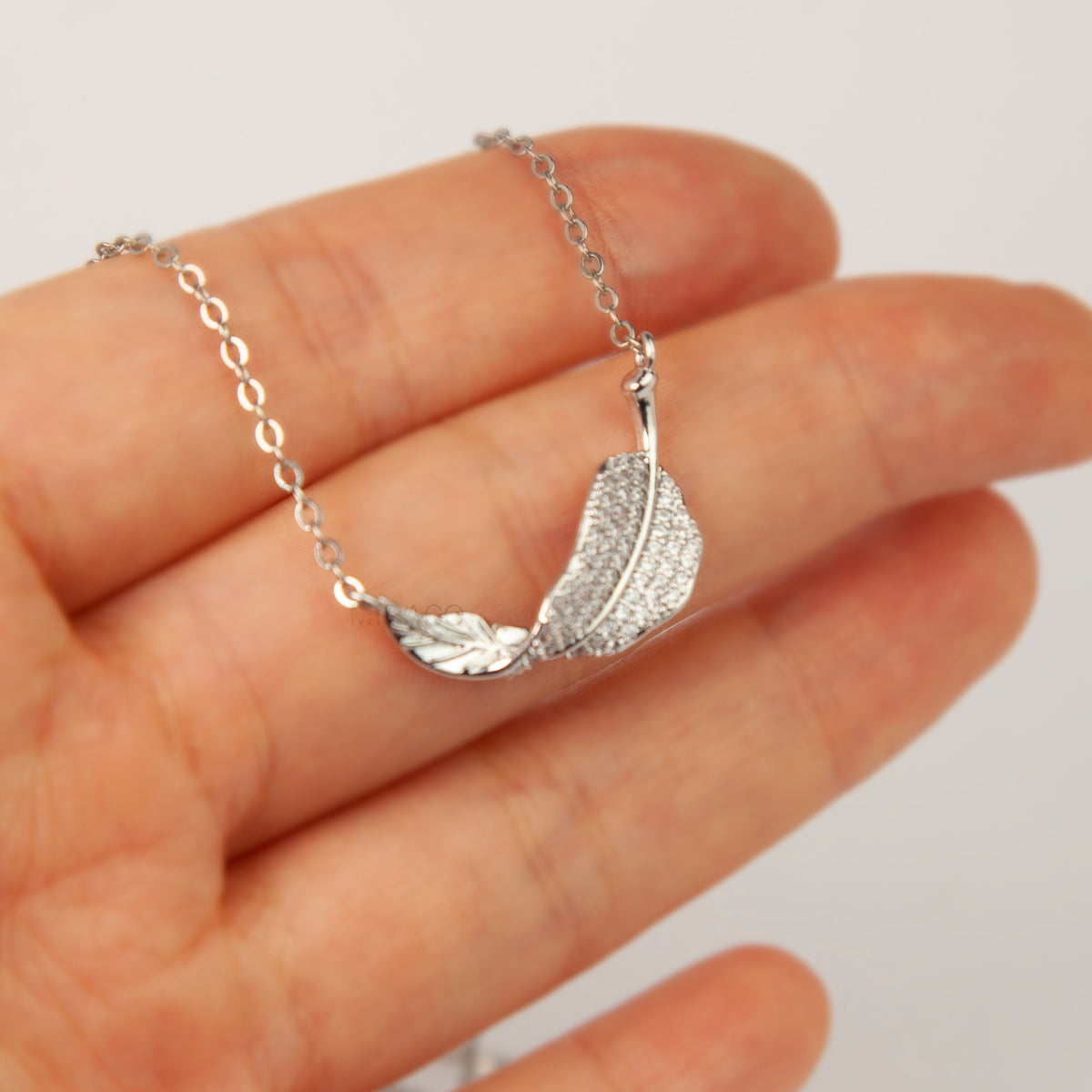 silver pavé crystal feather leaf pendant necklace and matching coil back clip-on earrings for unpierced ears.