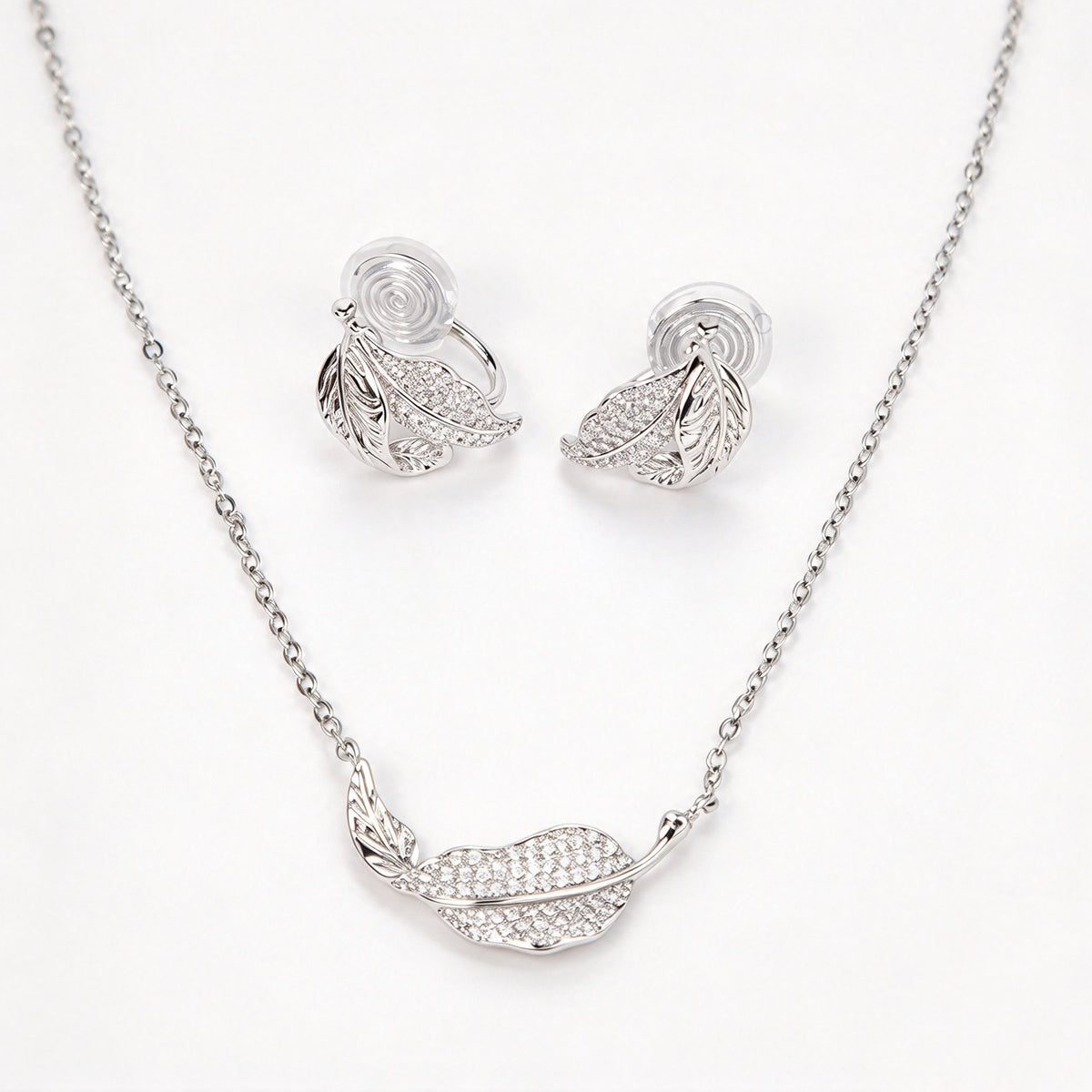 silver pavé crystal feather leaf pendant necklace and matching coil back clip-on earrings for unpierced ears.