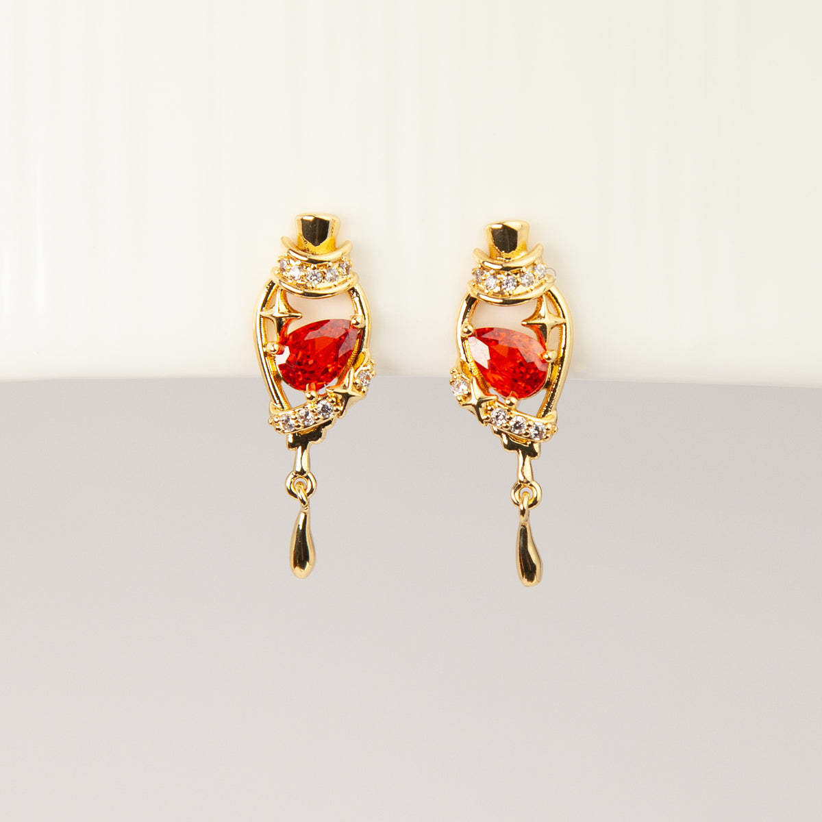 18K gold-plated royal crimson hat starburst teardrop clip-on earrings with red CZ stone and coil back non-pierced closure