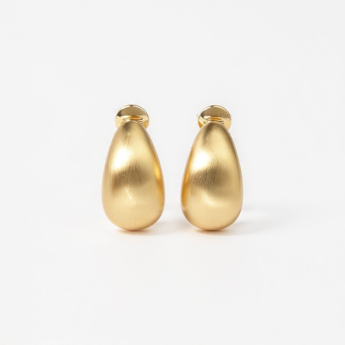 brushed matte gold curved dome huggie clip-on earrings with paddle clip back closure for unpierced ears.