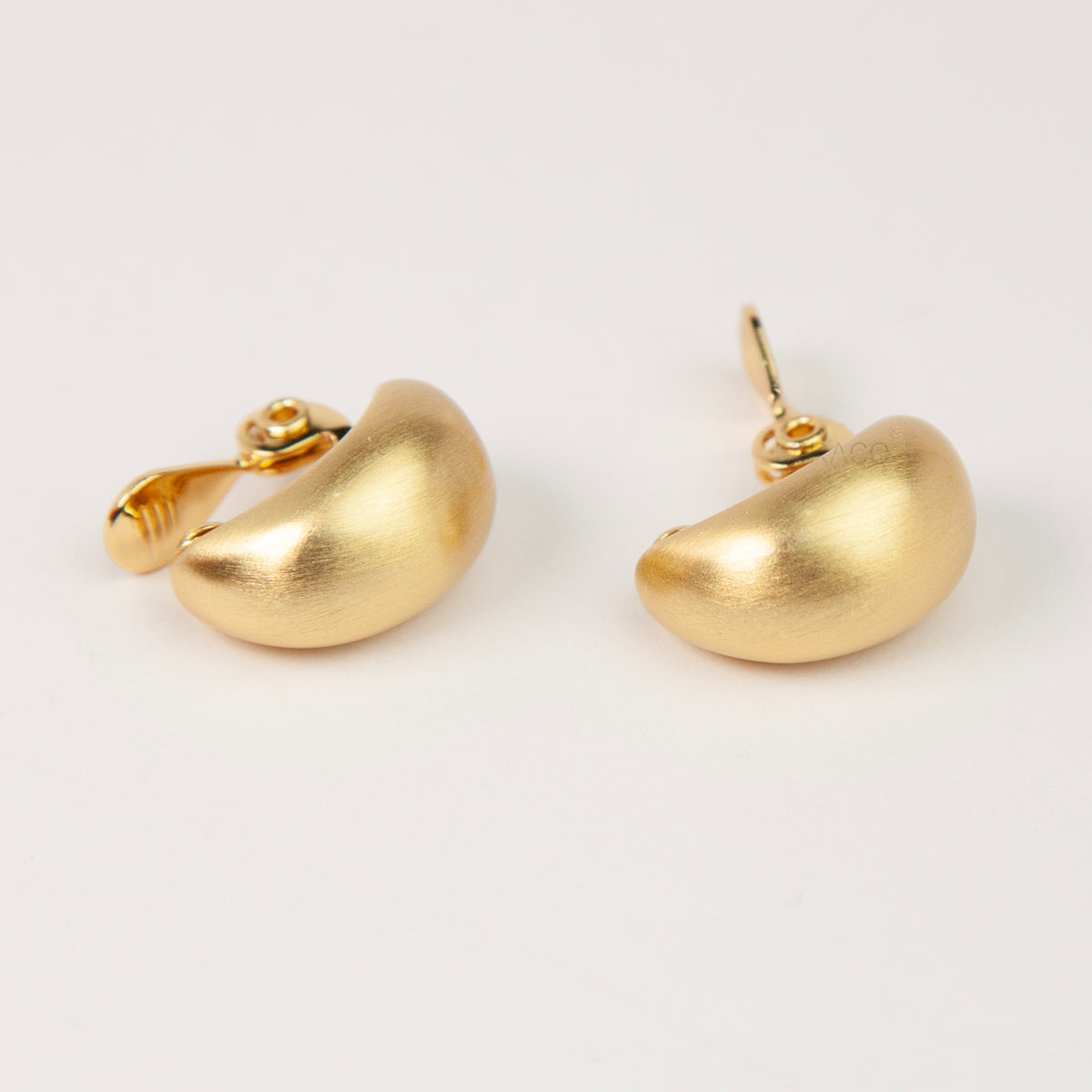 brushed matte gold curved dome huggie clip-on earrings with paddle clip back closure for unpierced ears.