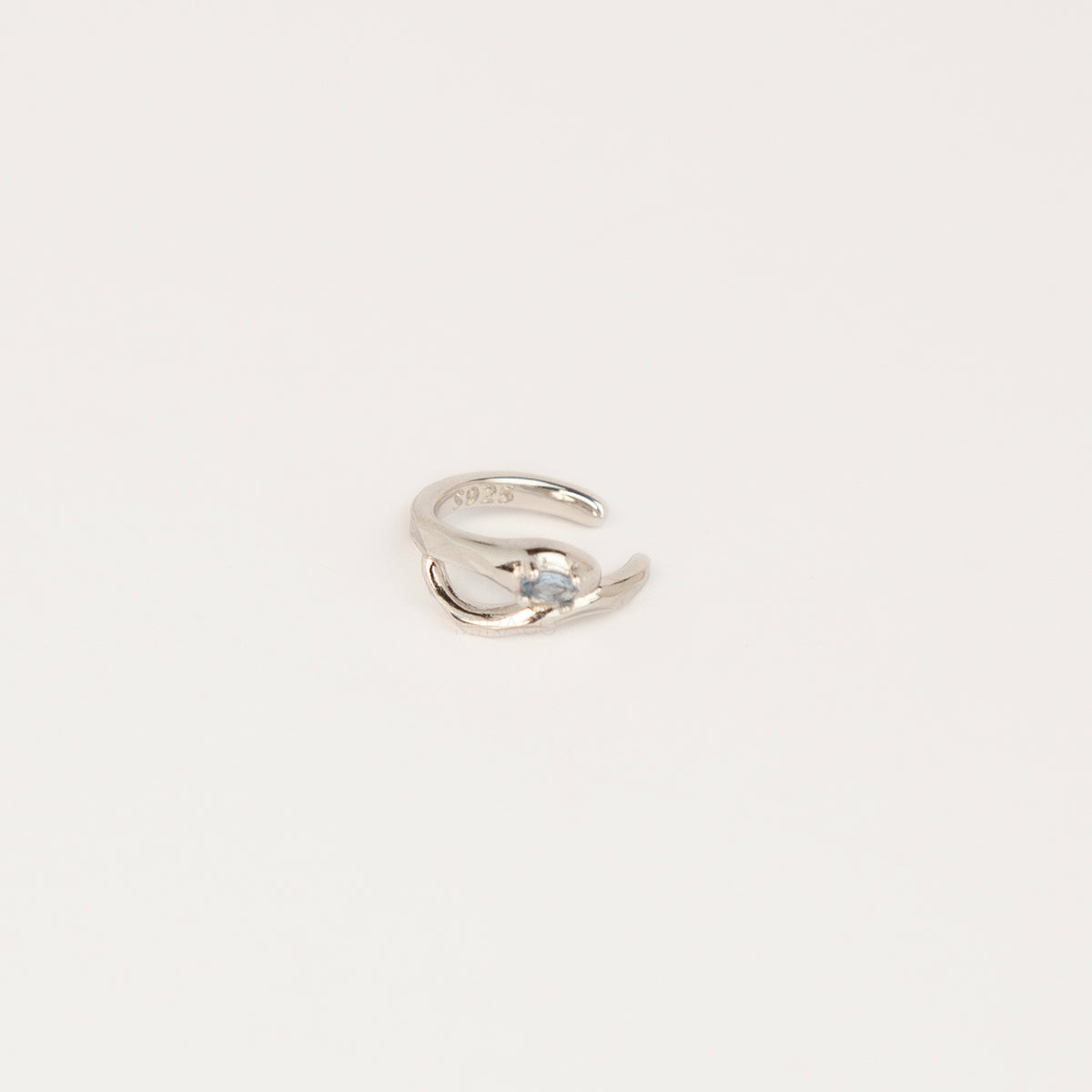 S925 sterling silver organic wave ear cuff clip-on featuring a small pale blue crystal stone worn on the conch of an unpierced ear.